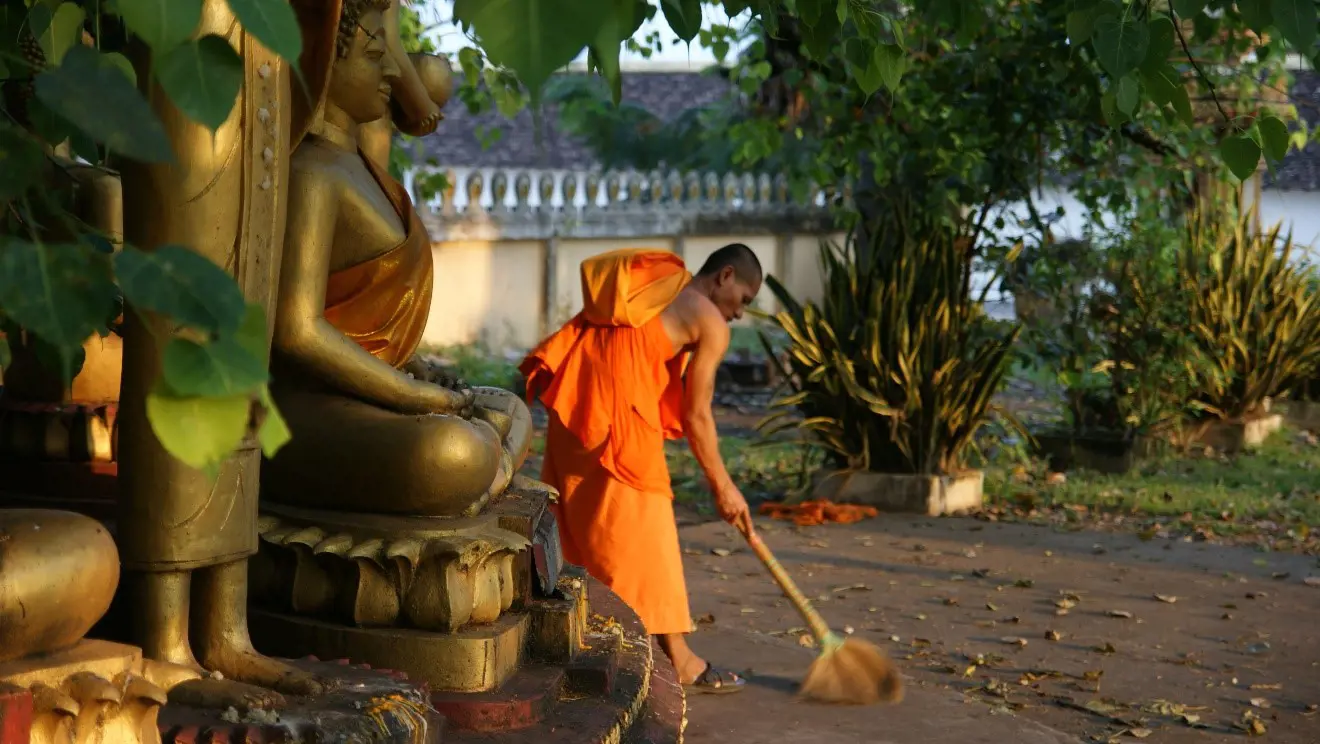 A person sweeping the street in Laos